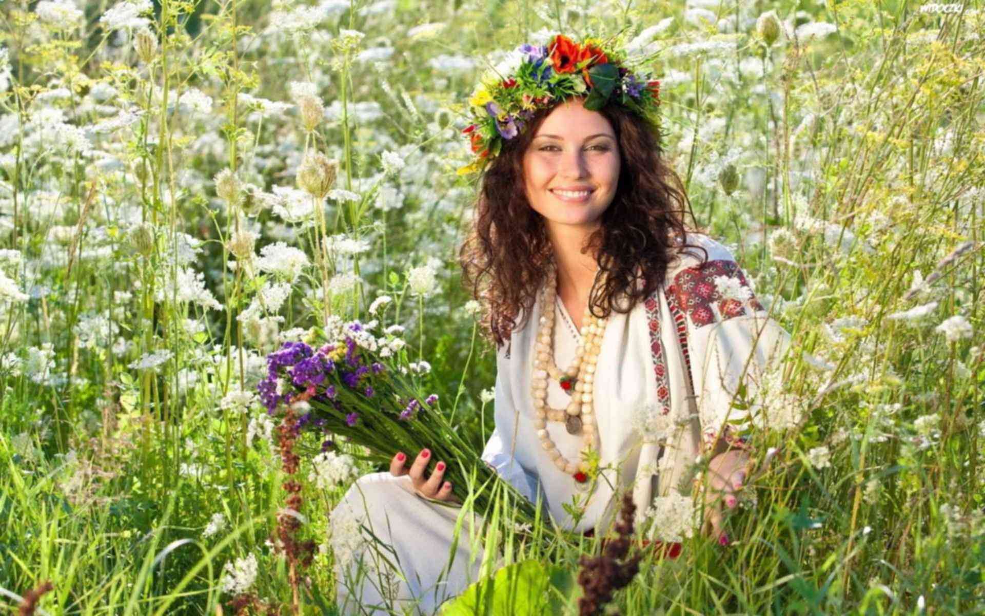 Деревенская красавица в венке из ярких цветов на берегу реки